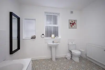 a white bathroom with a sink and a toilet at Blackpool Abode - Shaw Heights in Blackpool