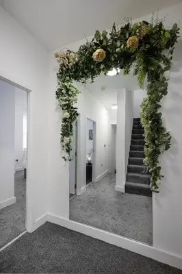 a hallway with a floral wreath on a stairway at Blackpool Abode - Shaw Heights in Blackpool