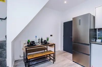 a kitchen with a table and a refrigerator at Beautiful Home In Bolton in Bolton