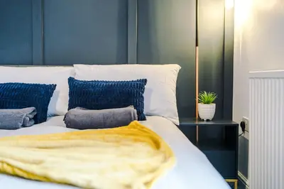 a bedroom with a white bed with blue pillows at Beautiful Home In Bolton in Bolton