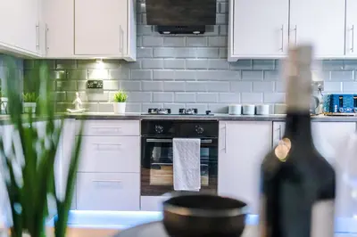 a kitchen with white cabinets and an oven at Beautiful Home In Bolton in Bolton