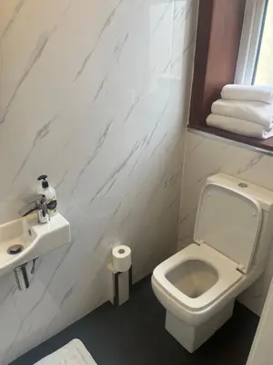 a bathroom with a white toilet and a sink at Shores Holiday Apartments in Blackpool