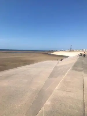 an empty runway with people walking on the beach at Shores Holiday Apartments in Blackpool