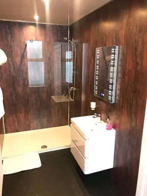 a bathroom with a shower and a white sink at Shores Holiday Apartments in Blackpool