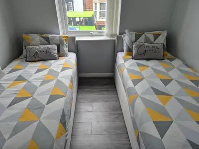 two beds in a small room with a window at House next to Anfield Stadium, Goodison Park in Liverpool