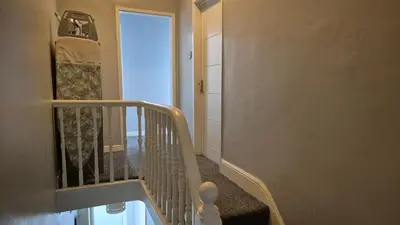 a hallway with a stairway leading to a room with a door at House next to Anfield Stadium, Goodison Park in Liverpool