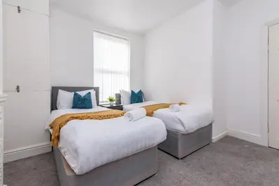 a bedroom with two beds and a window at Spacious 4-Bedroom Home Close to Liverpool City Centre in Liverpool