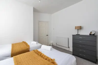 a bedroom with two beds and a black dresser at Spacious 4-Bedroom Home Close to Liverpool City Centre in Liverpool