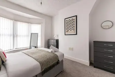 a bedroom with a bed and a dresser at Spacious 4-Bedroom Home Close to Liverpool City Centre in Liverpool
