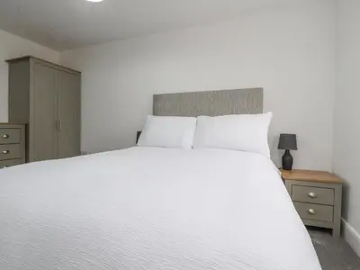 a bedroom with a large white bed and two night stands at Apple Tree Cottage in Preston