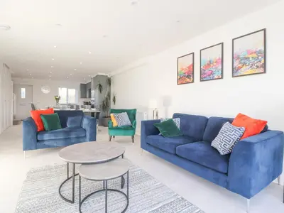 a living room with two blue couches and a table at Apple Tree Cottage in Preston