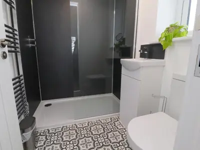 a bathroom with a shower and a toilet and a sink at Pear Tree Cottage in Preston