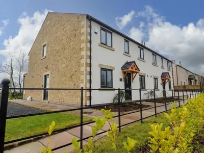 a building with a black fence in front of it at Pear Tree Cottage in Preston