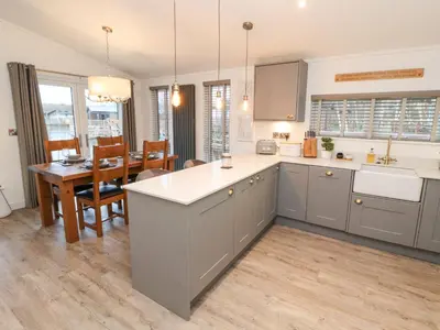 a kitchen and dining room with a table and a counter at 12A Lake Escape in Carnforth