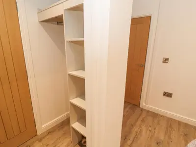 a closet with white shelves in a room at 12A Lake Escape in Carnforth