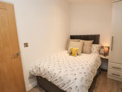 a bedroom with a bed with a yellow pillow on it at 12A Lake Escape in Carnforth