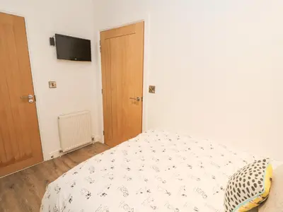 a bedroom with a bed and a television on the wall at 12A Lake Escape in Carnforth