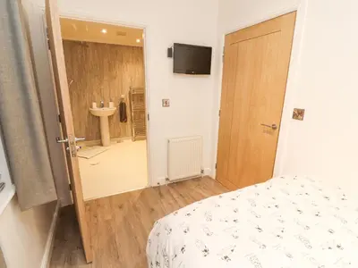 a bedroom with a bed and a bathroom with a sink at 12A Lake Escape in Carnforth