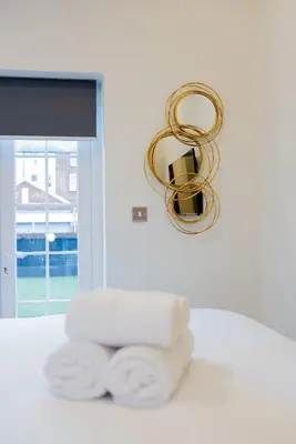 a bathroom with towels and a chandelier at Lethbridge Villa 49 3-bedroom Apartment with private HOT TUB,Fibre WiFi, free parking, sleeps 6 in Southport