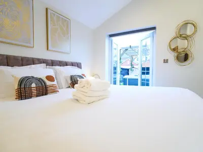 a white bed with a pile of towels on it at Lethbridge Villa 49 3-bedroom Apartment with private HOT TUB,Fibre WiFi, free parking, sleeps 6 in Southport
