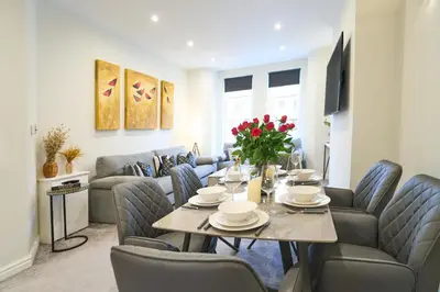 a living room with a table and a couch at Lethbridge Villa 49 3-bedroom Apartment with private HOT TUB,Fibre WiFi, free parking, sleeps 6 in Southport