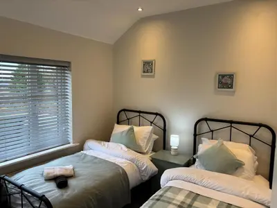 a bedroom with two beds and a window at Stumps and Bails Families and contractors welcome in Ormskirk