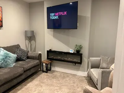 a living room with a couch and a flat screen tv at Stumps and Bails Families and contractors welcome in Ormskirk