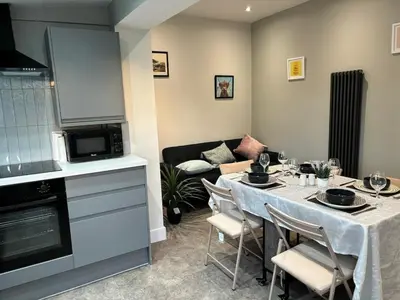 a dining room with a table and a living room at Stumps and Bails Families and contractors welcome in Ormskirk