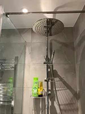 a shower with a shower head and a shower at Stumps and Bails Families and contractors welcome in Ormskirk