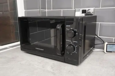 a black microwave oven sitting on top of a counter at Spacious Central Liverpool Home in Liverpool
