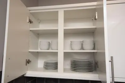 a cupboard with plates and bowls in it at Spacious Central Liverpool Home in Liverpool