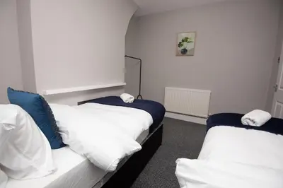 two beds in a room with white and blue at Spacious Central Liverpool Home in Liverpool