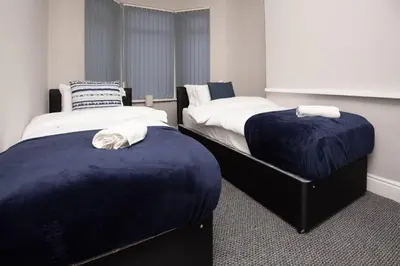 two beds sitting next to each other in a room at Spacious Central Liverpool Home in Liverpool