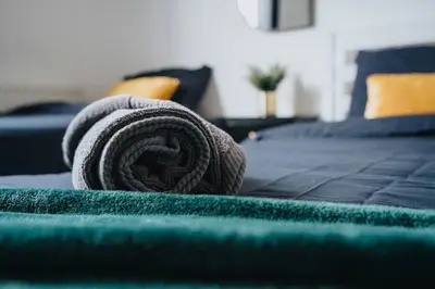 a rolled up towel sitting on top of a bed at LFC Stay 1 Min to Stadium WM Pet Friendly in Liverpool