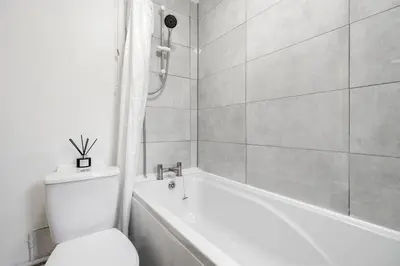 a white bathroom with a toilet and a bath tub at LFC Stay 1 Min to Stadium WM Pet Friendly in Liverpool