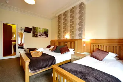 a hotel room with two beds and a television at The Derby Hotel in Blackpool