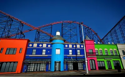 a colorful building with a ferris wheel in the background at The Derby Hotel in Blackpool