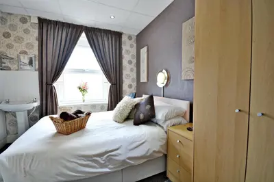 a bedroom with a bed with a sink and a window at The Derby Hotel in Blackpool