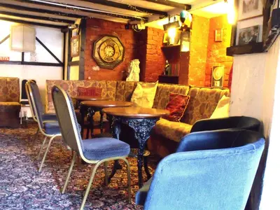 a restaurant with tables and chairs and a couch at The Derby Hotel in Blackpool