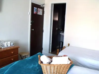 a bedroom with a bed and a basket on the bed at The Derby Hotel in Blackpool