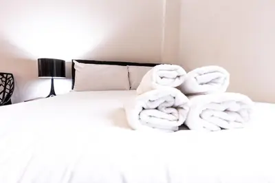 a bed with two towels stacked on top of it at Stunning Centrally Located Studio Apt in Liverpool