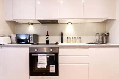 a kitchen with a stove with a bottle of wine at Stunning Centrally Located Studio Apt in Liverpool