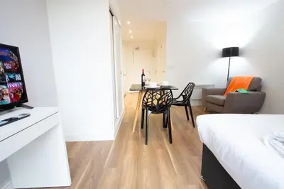 a room with a bed and a table with a chair at Stunning Centrally Located Studio Apt in Liverpool