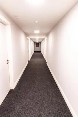 an empty hallway in an office building with white walls and carpet at Stunning Centrally Located Studio Apt in Liverpool