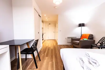 a bedroom with a bed and a desk and a couch at Stunning Centrally Located Studio Apt in Liverpool