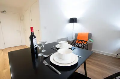 a black table with a bottle of wine and a glass at Stunning Centrally Located Studio Apt in Liverpool
