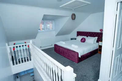 a bedroom with a bed with a purple headboard at 1 minute walk to Liverpool Stadium Free Private Parking, Anfield Liverpool Entire House in Liverpool