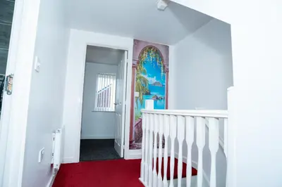 a white staircase with a red carpet and a stained glass window at 1 minute walk to Liverpool Stadium Free Private Parking, Anfield Liverpool Entire House in Liverpool