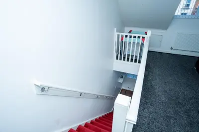 a white staircase in a room with a crib at 1 minute walk to Liverpool Stadium Free Private Parking, Anfield Liverpool Entire House in Liverpool