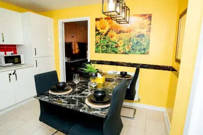 a dining room with a table and chairs and yellow walls at 1 minute walk to Liverpool Stadium Free Private Parking, Anfield Liverpool Entire House in Liverpool
